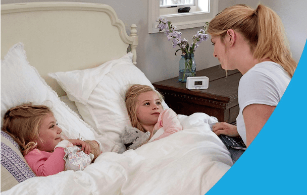 family with carbon monoxide detector on bedside