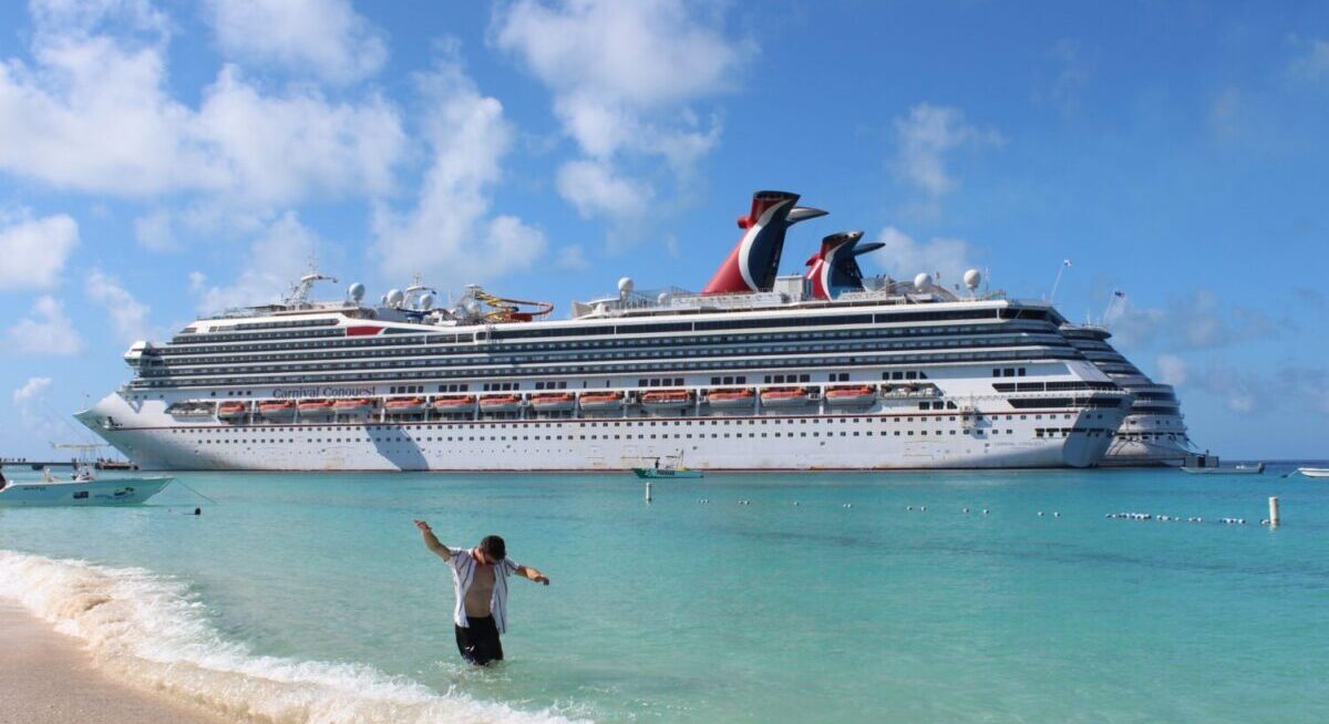 carnival cruise ship with a person swimming in the ocean