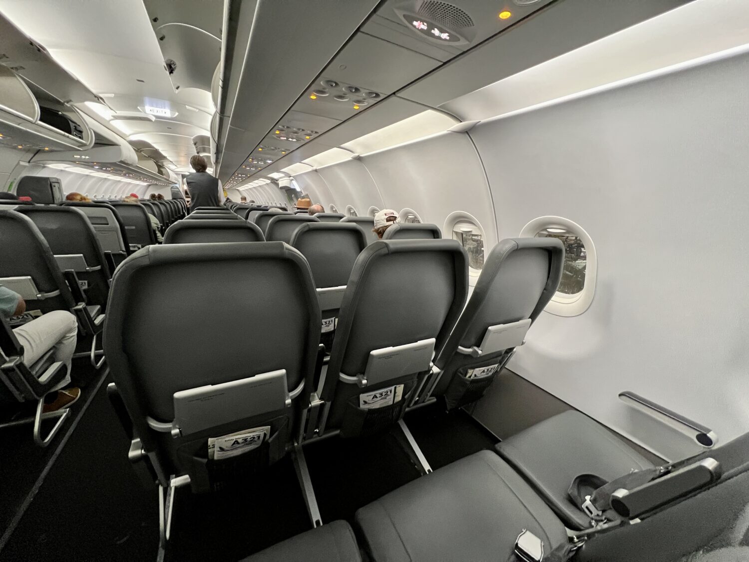several rows of plain black airplane seats with no seatback monitor