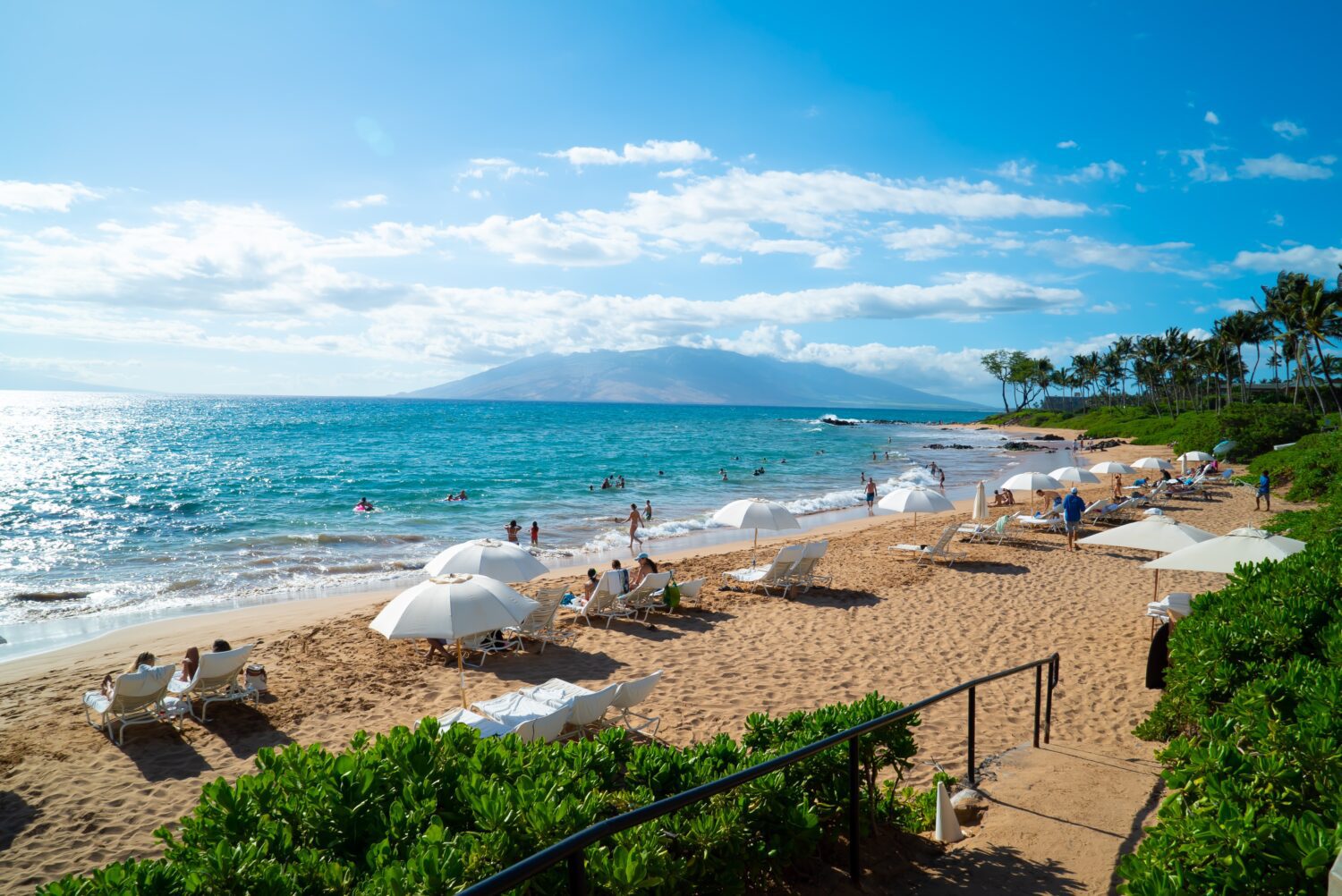 A scenic beach with colorful umbrellas and people enjoying the sun and sand