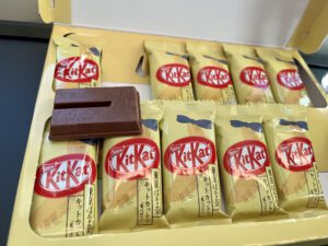 several packaged kit kat bars with one unwrapped