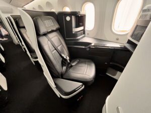 black leather business class seat along windows of the plane