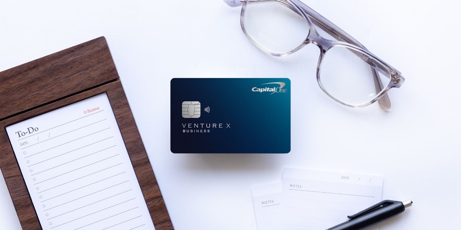The Capital One Venture X Business Card with a to-do list, glasses, and pen.
