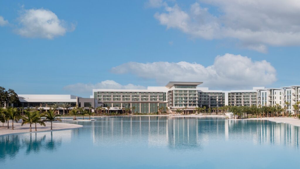 a long white hotel building behind a large blue lagoon