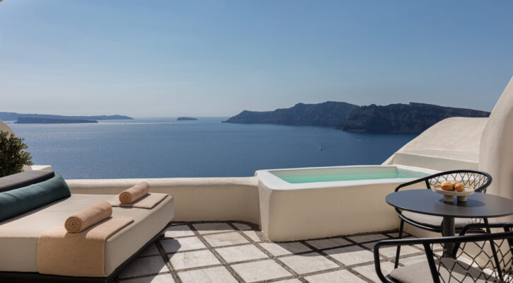 a deck overlooking the ocean with a day bed, chairs and a small plunge pool