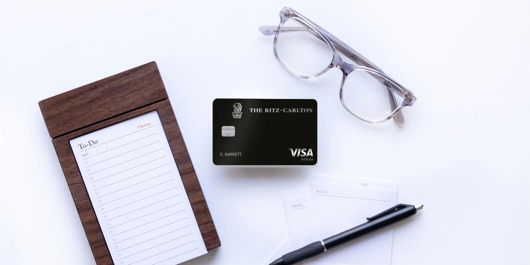 Ritz Carlton Credit Card with glasses, a pen, and a notepad.