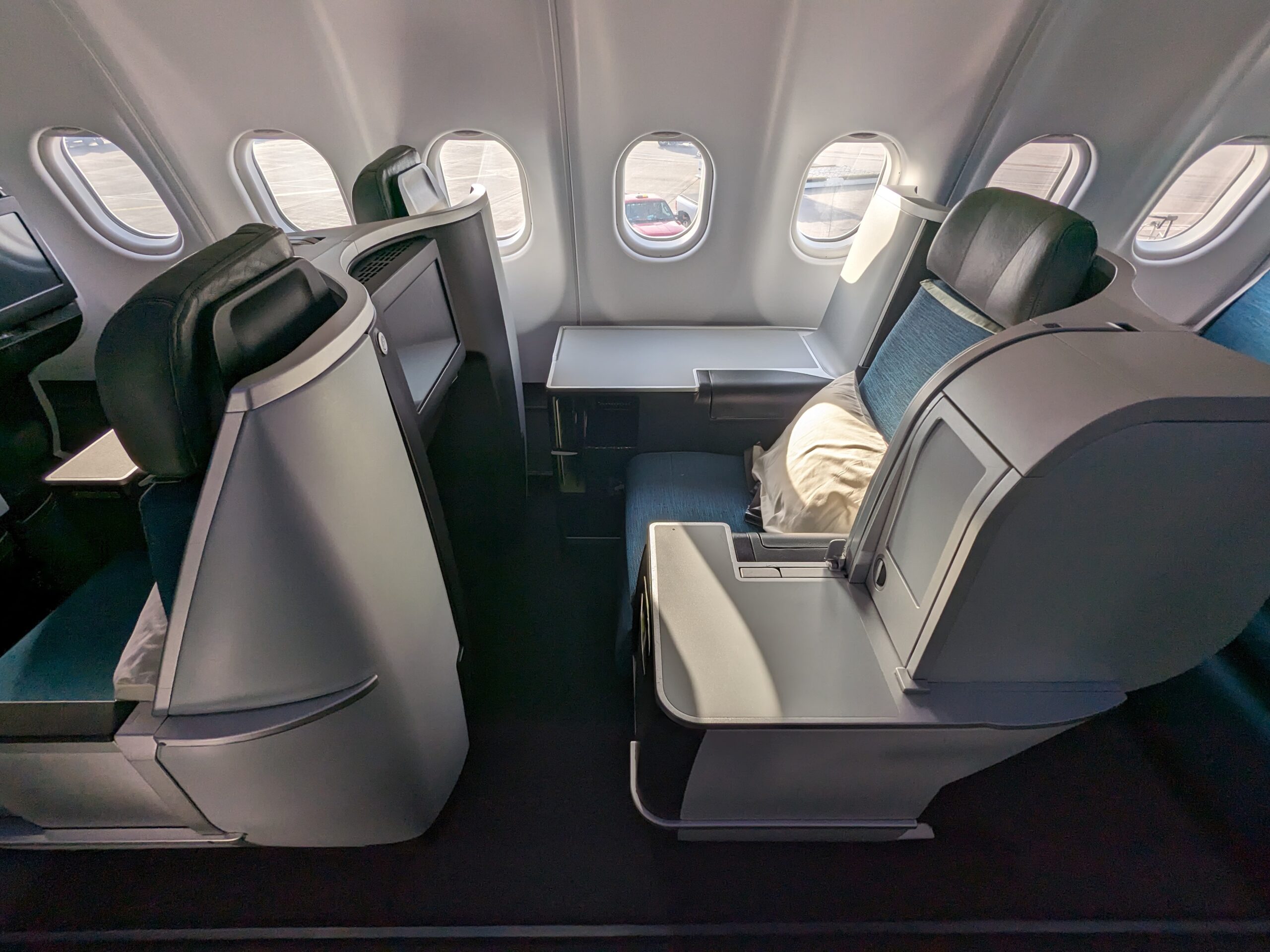 Lie-Flat for Less: 7 Airlines That Offer Cheap Business Class Upgrades 11 business class seat with green upholstery