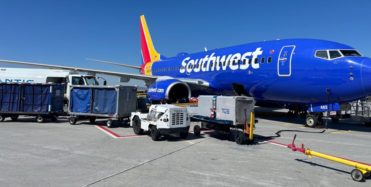 6 Predictions for 2025 Airfare: Tougher Award Booking & Higher Prices (Except First Class) 10 a southwest plane with several baggage carriages in front of it