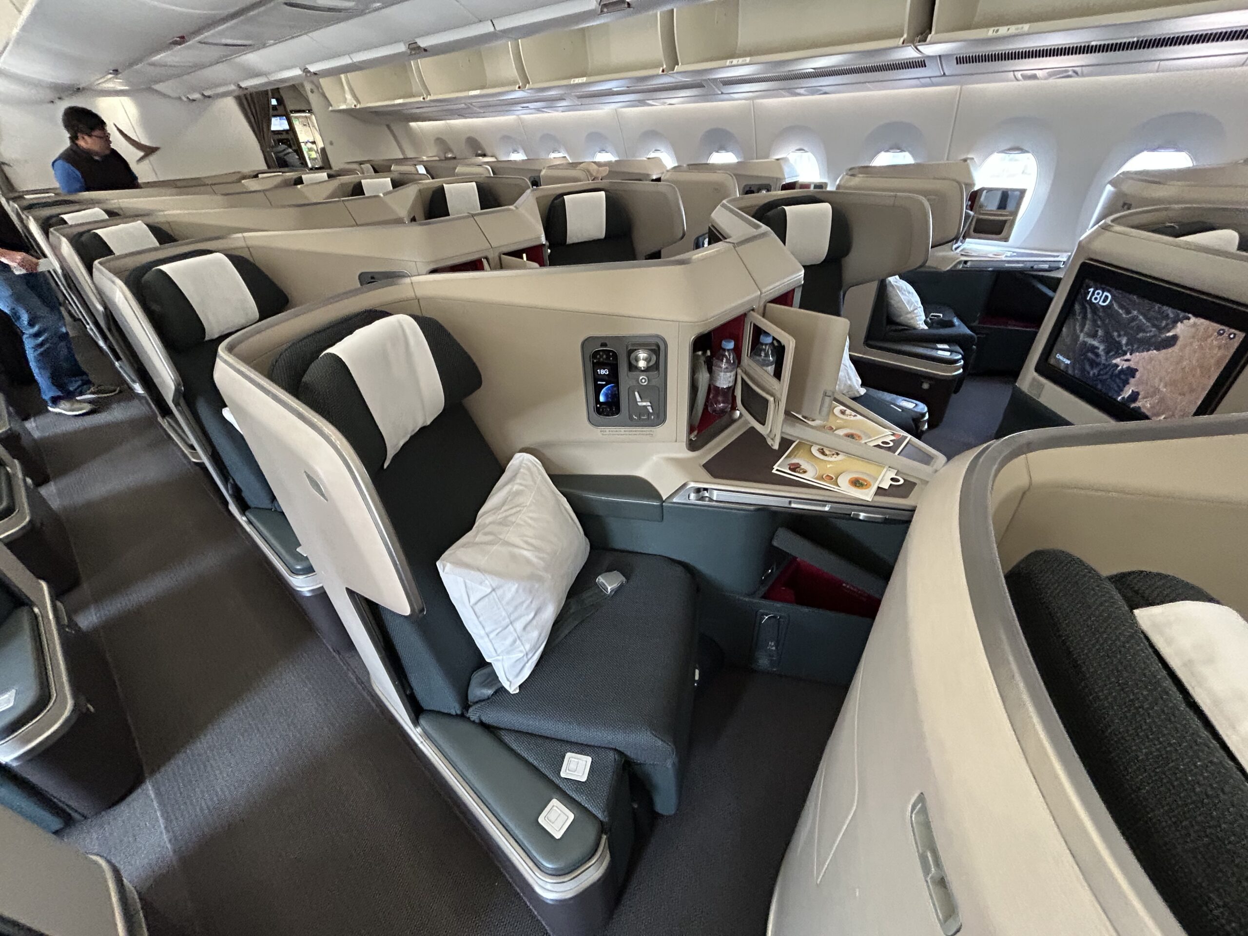 rows of business class seats with white and green designs 