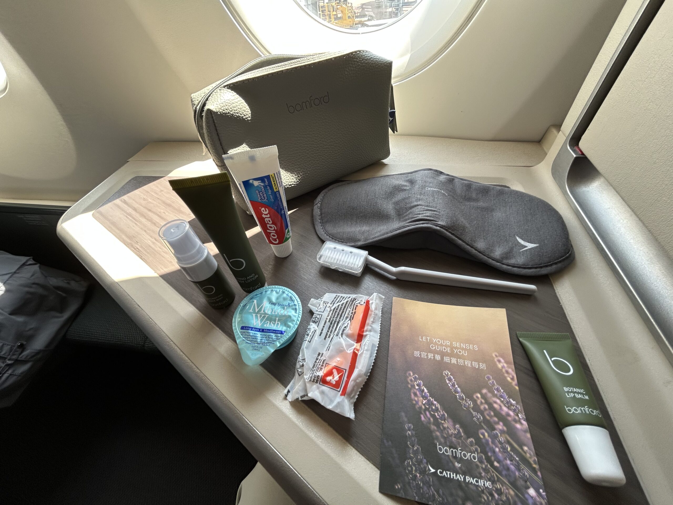 A leather pouch, eye mask, and toiletries laid out on a side table. 