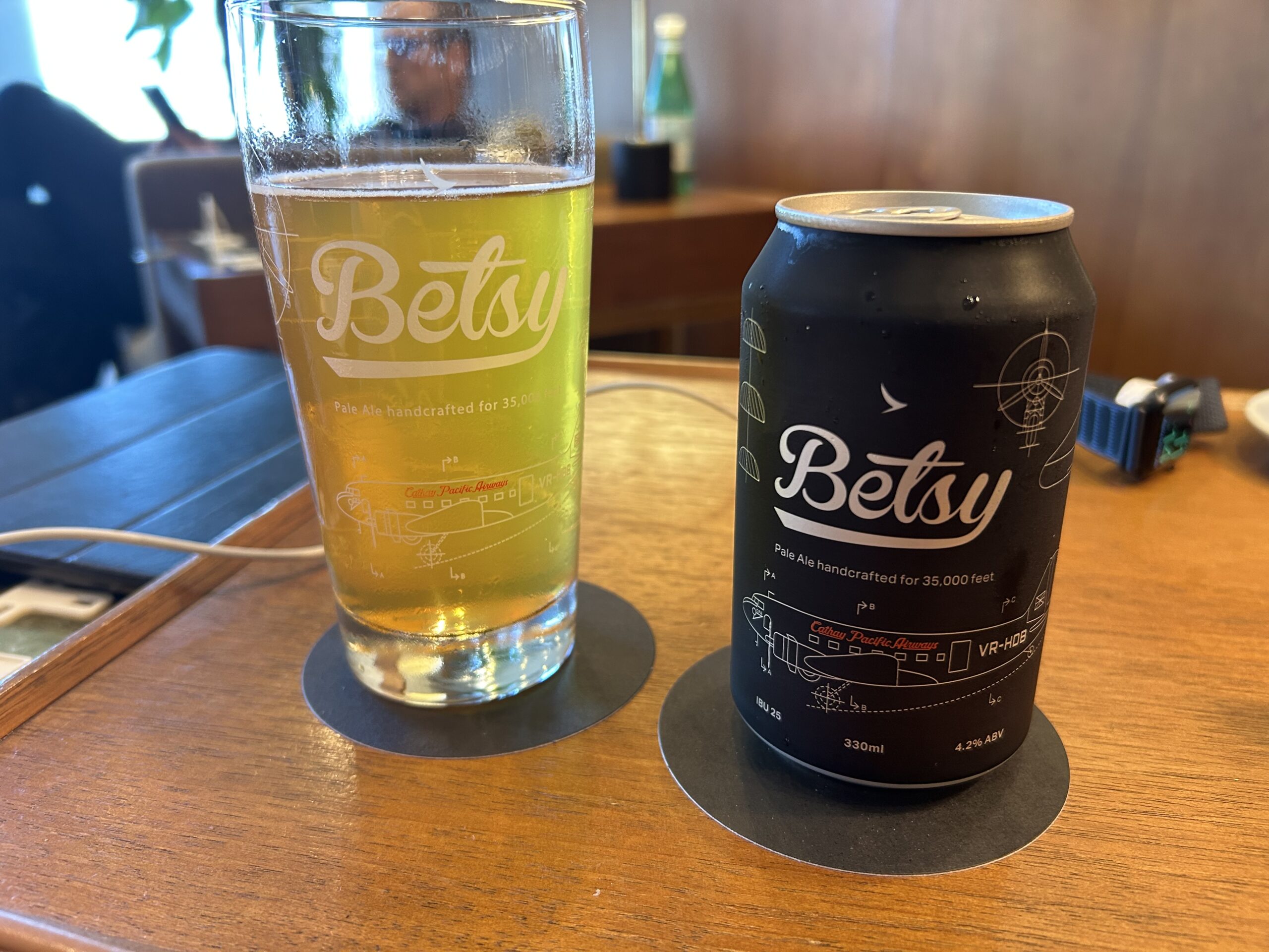 a Betsy beer glass and a can of Betsy beer on a table 