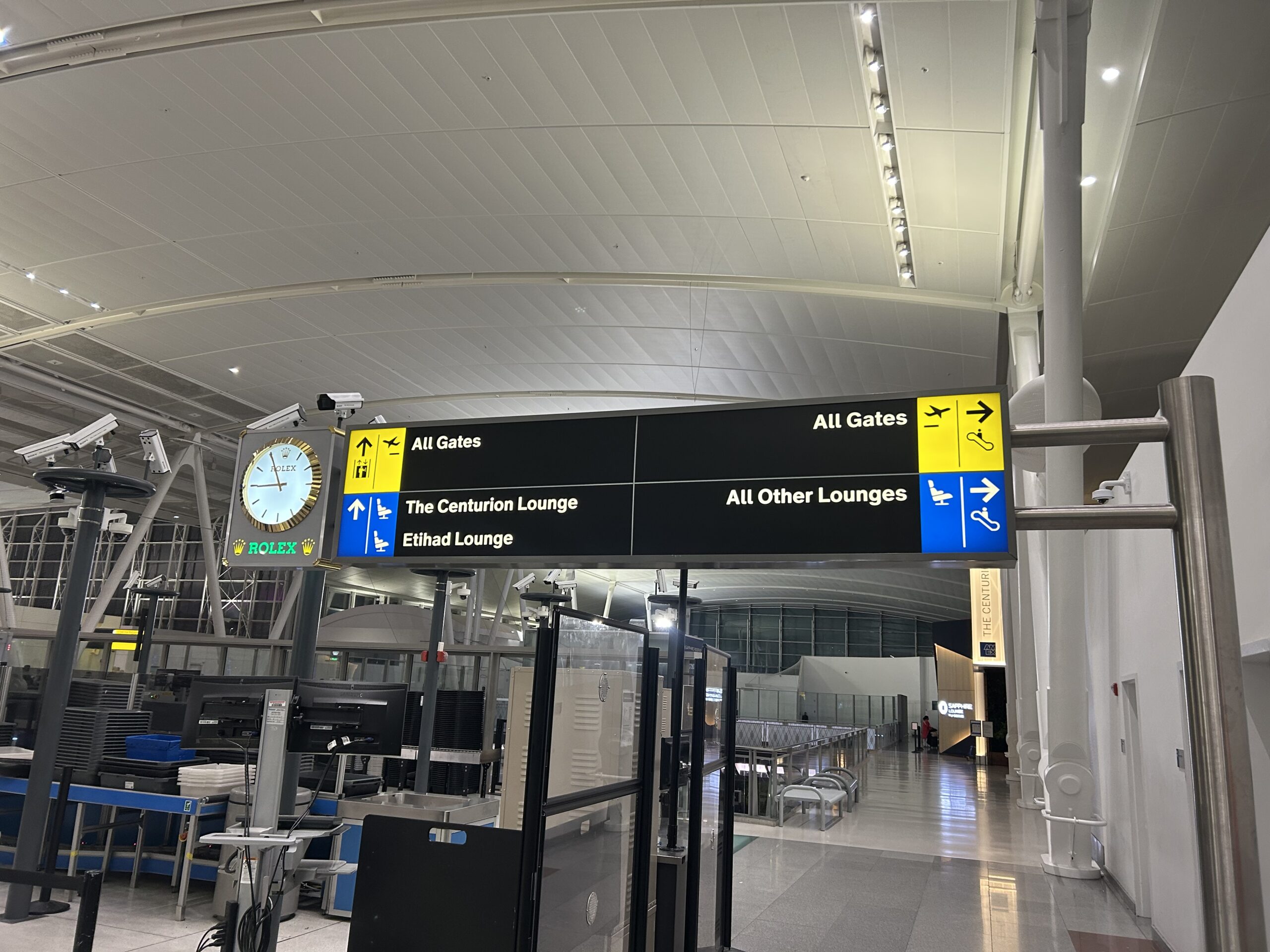 Sign directing passengers to The Centurion Lounge and the Etihad Lounge ahead and all other lounges to the right. 
