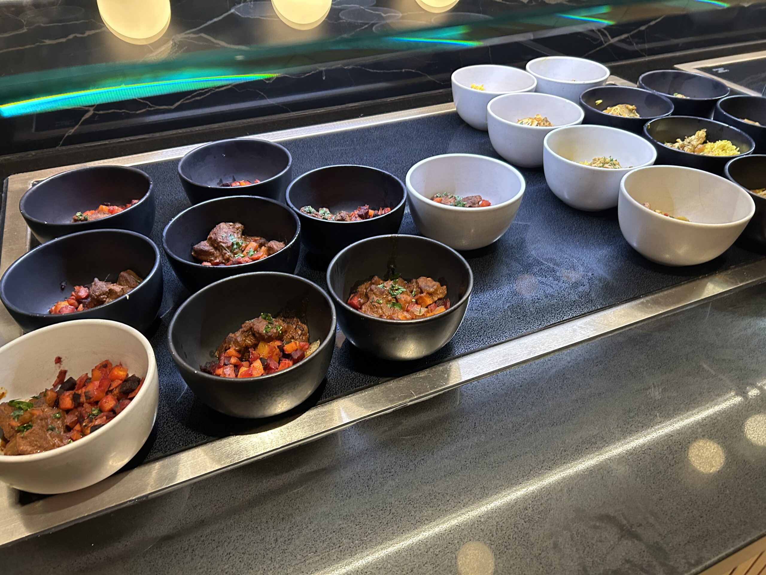 bowls of curry and rice on a buffet