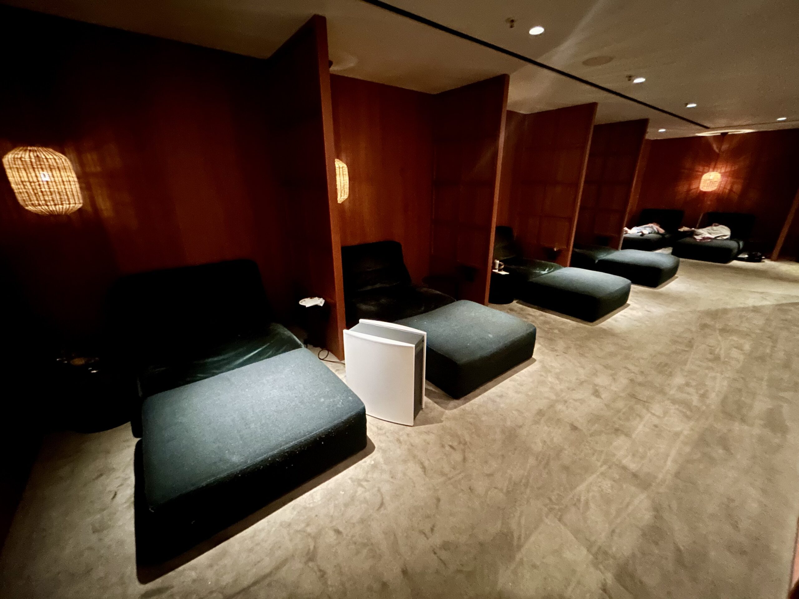 row of dark green daybeds inside an airport lounge