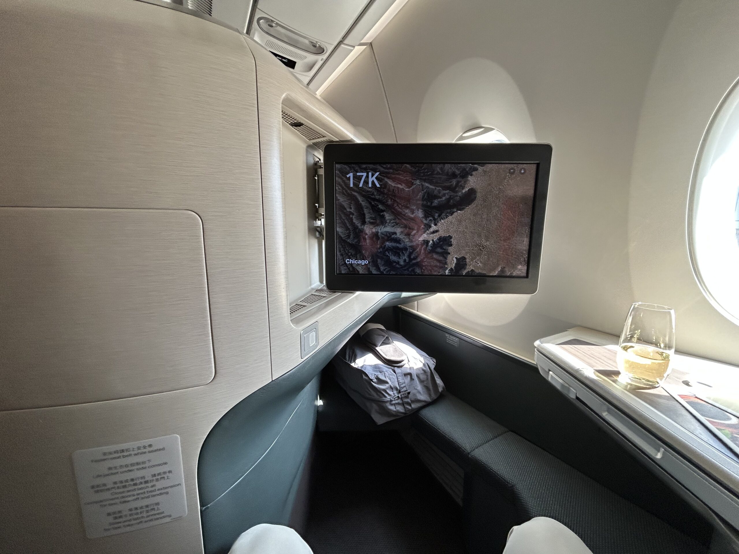 A video monitor pulled out from the back of an airplane seat. 