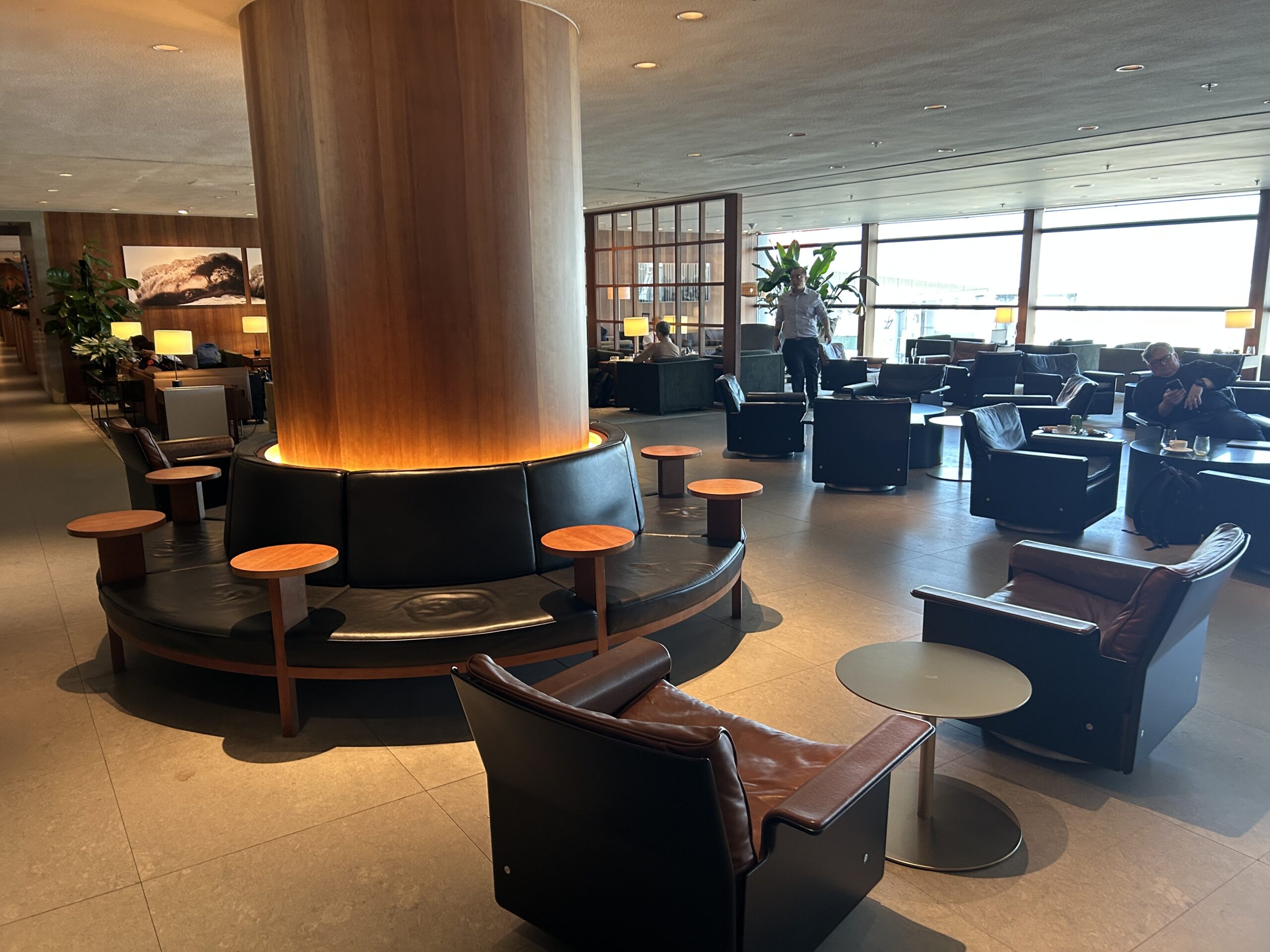 cafe tables and armchairs around a column in an airport lounge