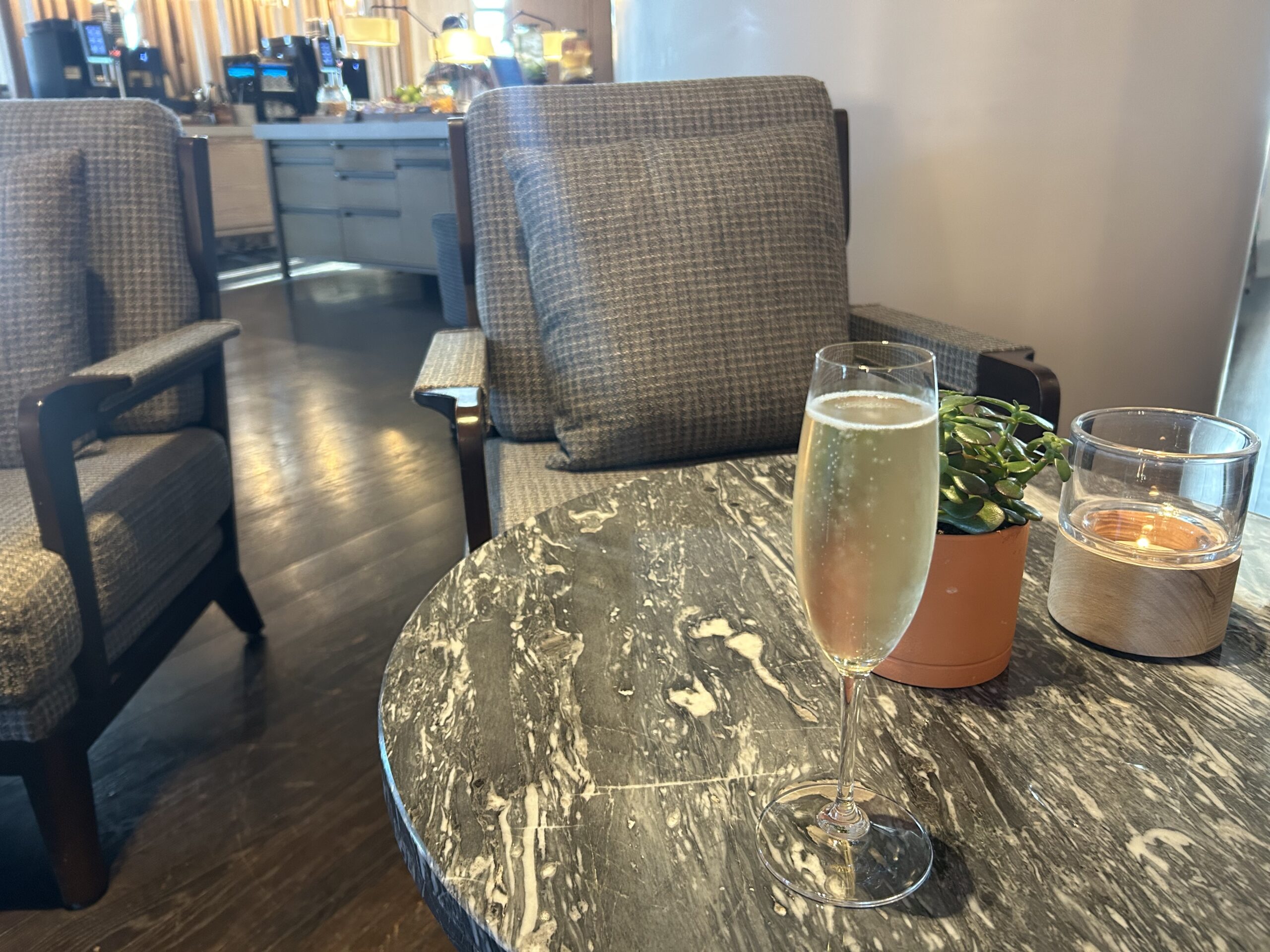 a glass of prosecco on a round marble table 
