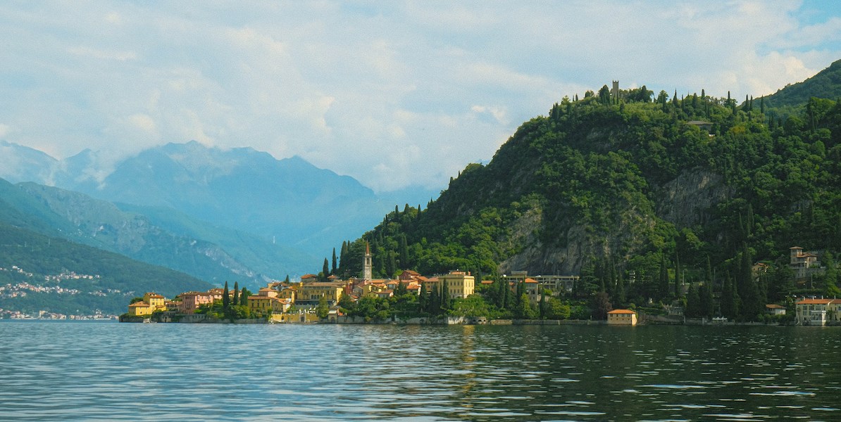 a lake with a small town and mountains