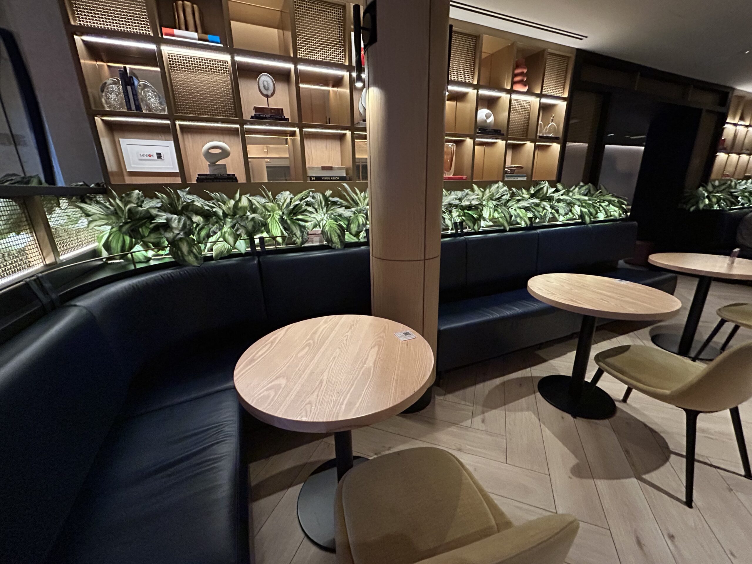 a few empty cafe tables and benches inside the Chase lounge