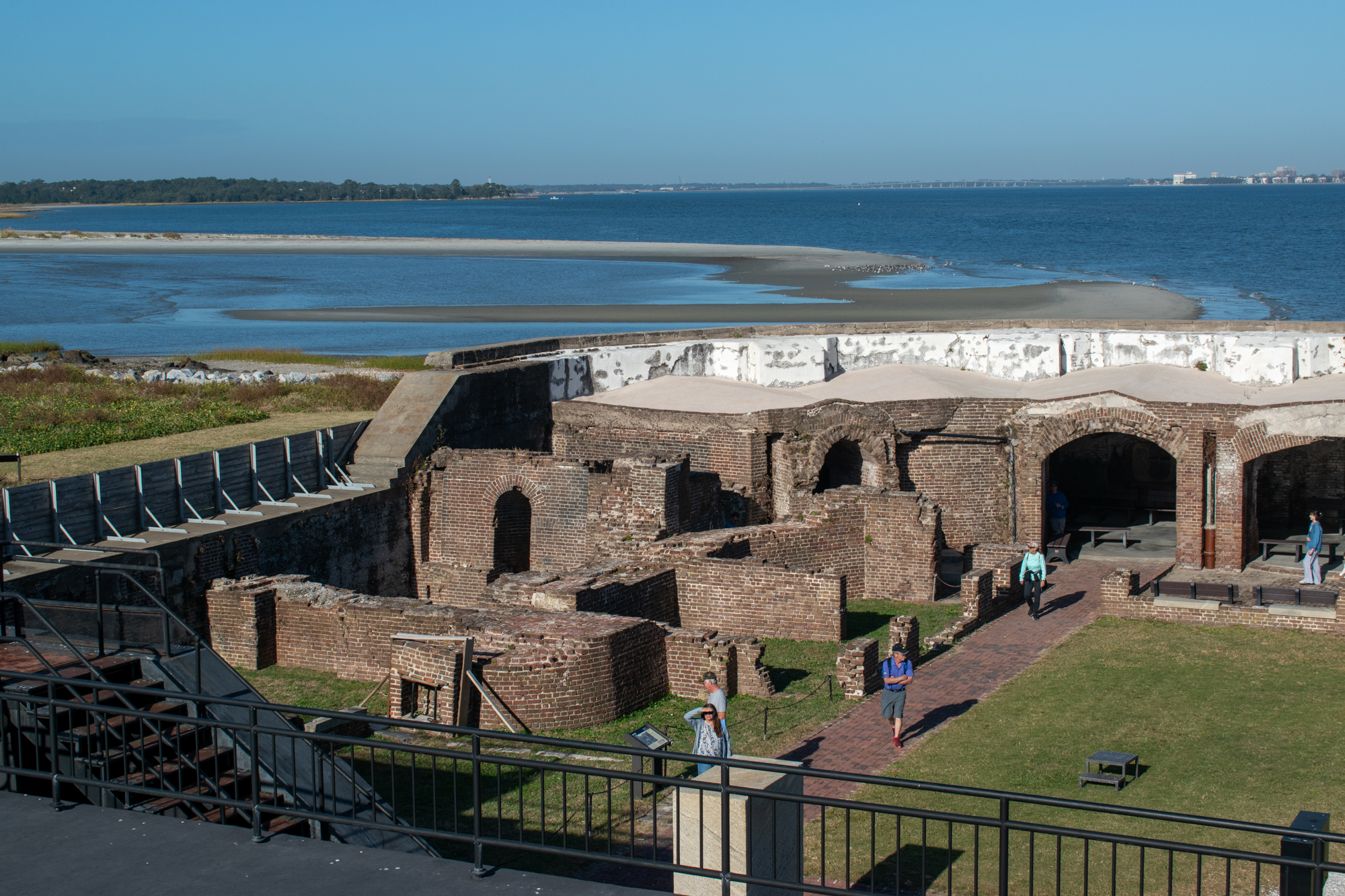 Fort Sumter from the top deck, looking down at the old fort walls and the ocean and city behind. 