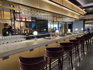 red stools pushed up against a long bar with gold accents