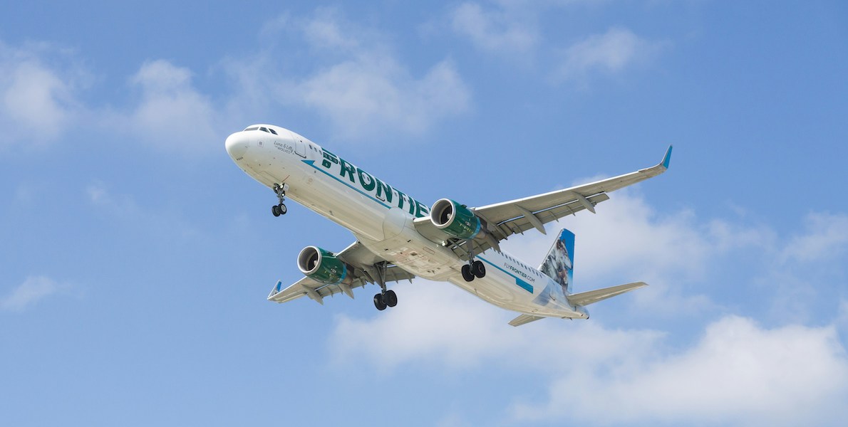a frontier airlines airplane flying in the sky