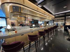 a long bar with several stools and employees