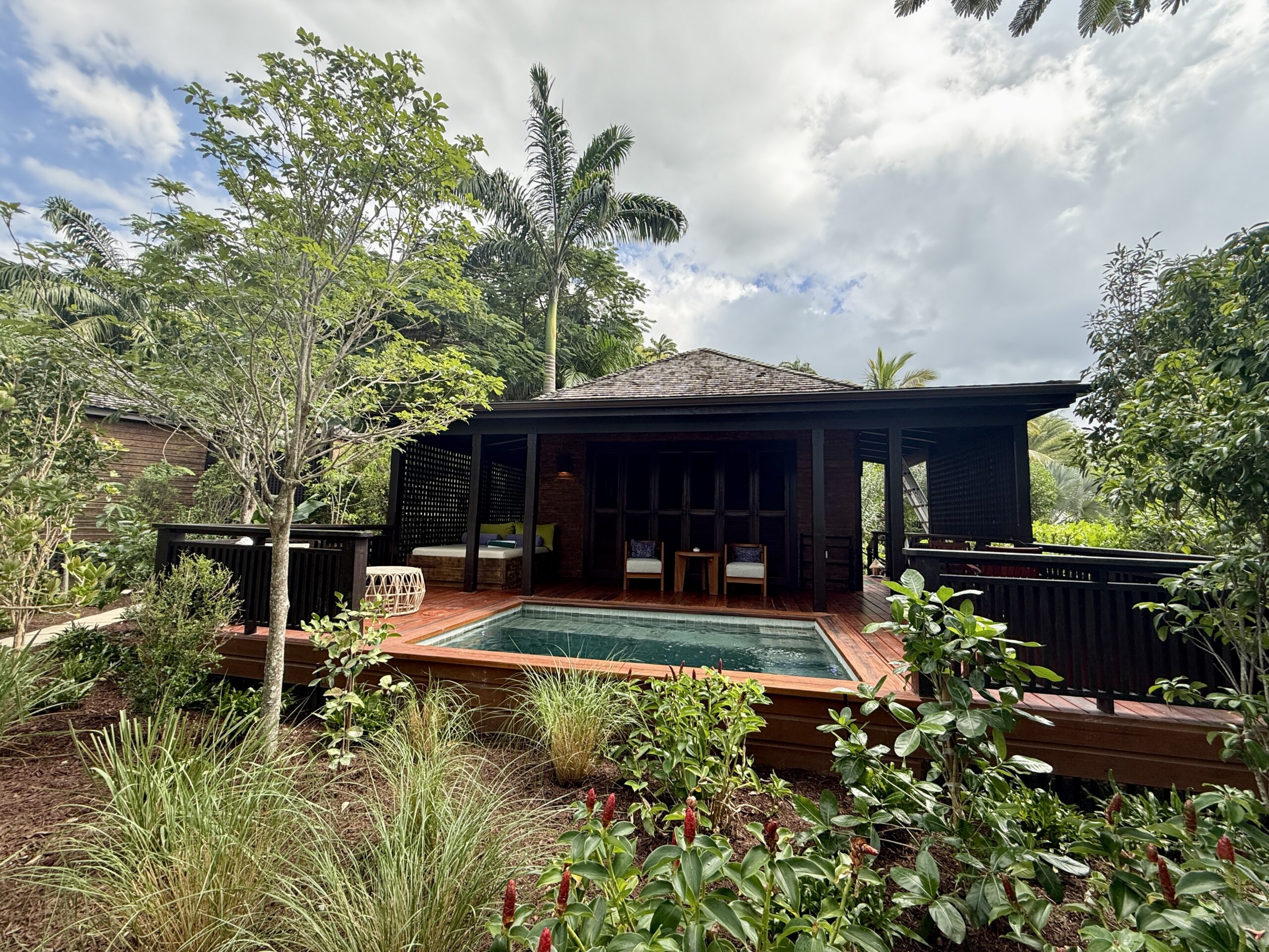 villa with a private pool on the deck surrounded by plants