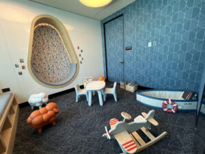 a kids room with several orange toys and small blue tables and chairs