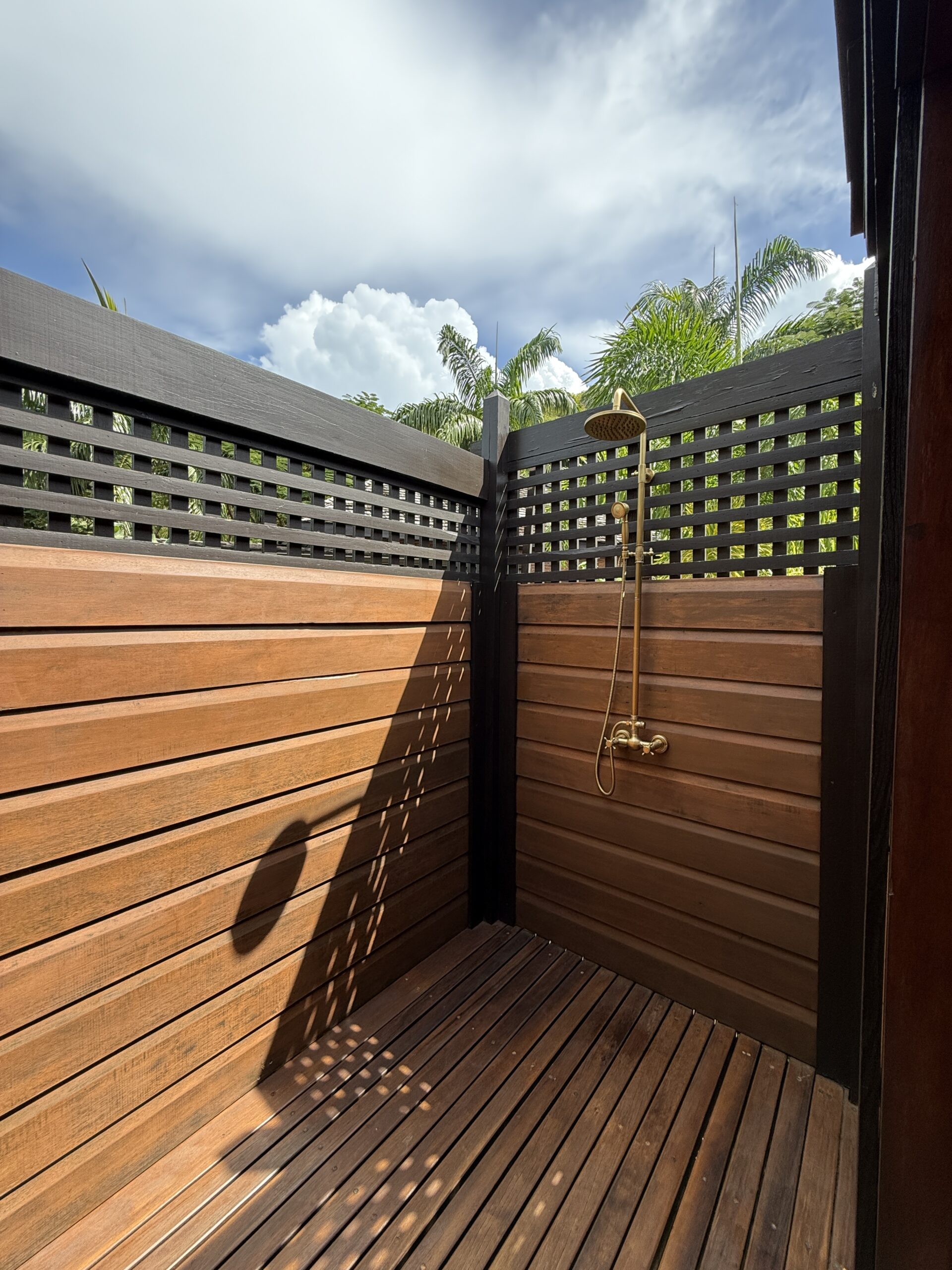 an outdoor shower with high wooden walls