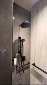 a shower head with gray marble walls