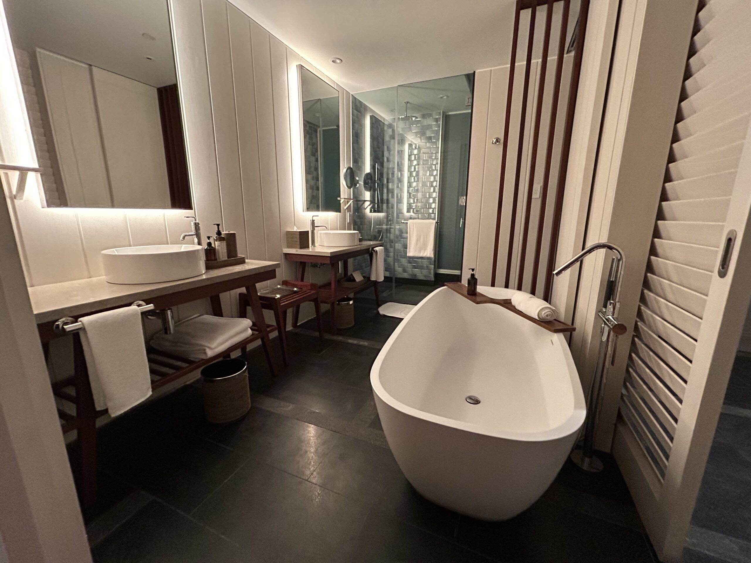 hotel bathroom with a big tub and two sinks and a shower. 