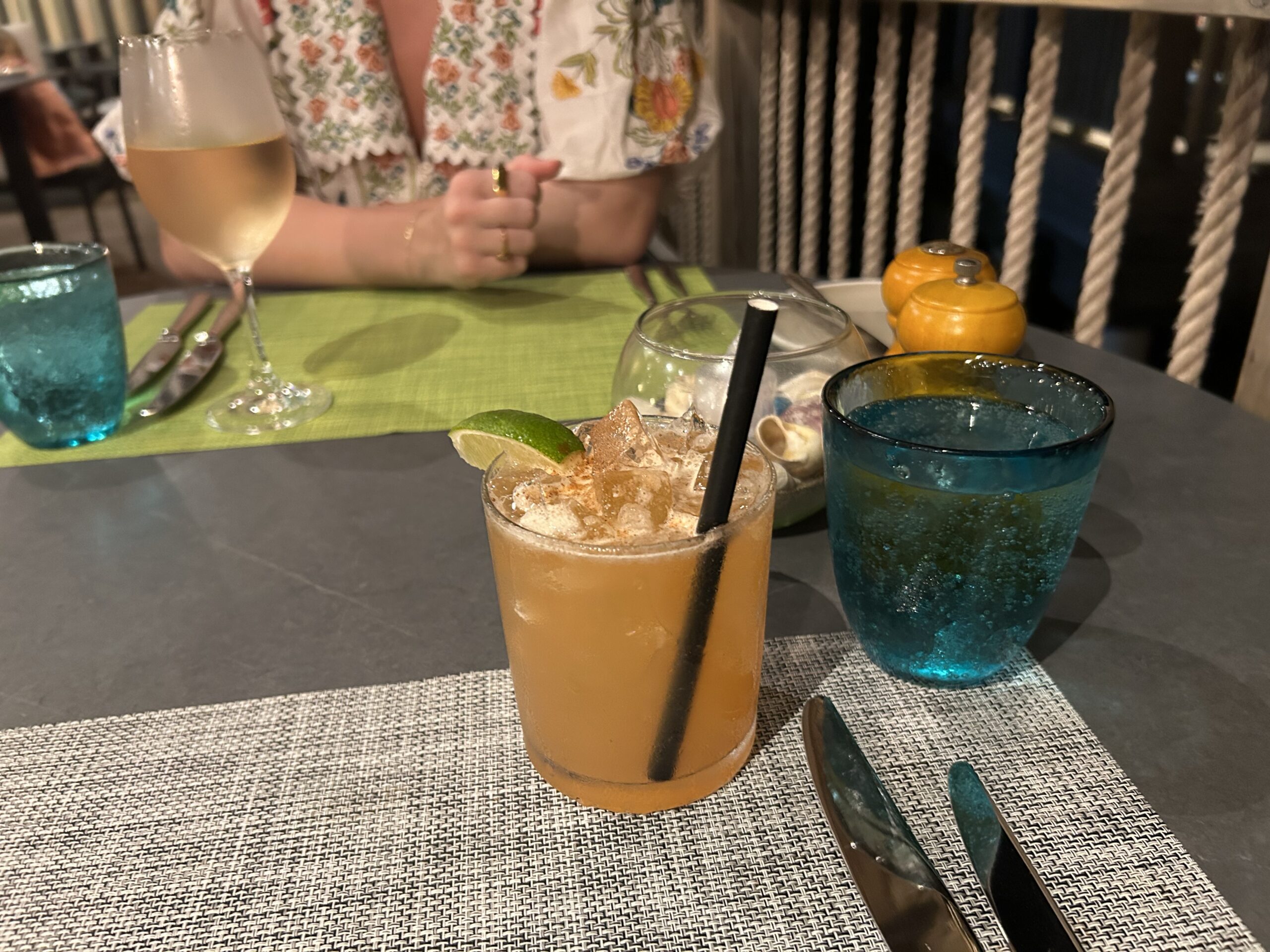 an orange cocktail with a lime wedge and a glass of chilled rose 