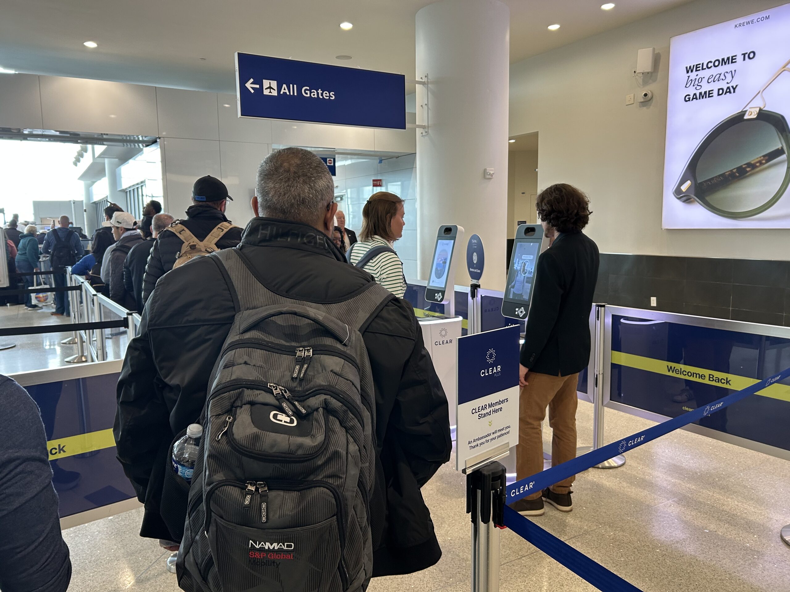 A CLEAR representative helps a customer navigate the new Lane of the Future EnVe pods at airport security. 