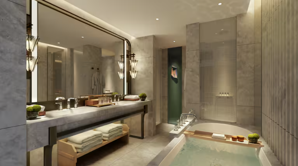 Bathroom with marble floors, walls, and vanity and a large bathtub. 