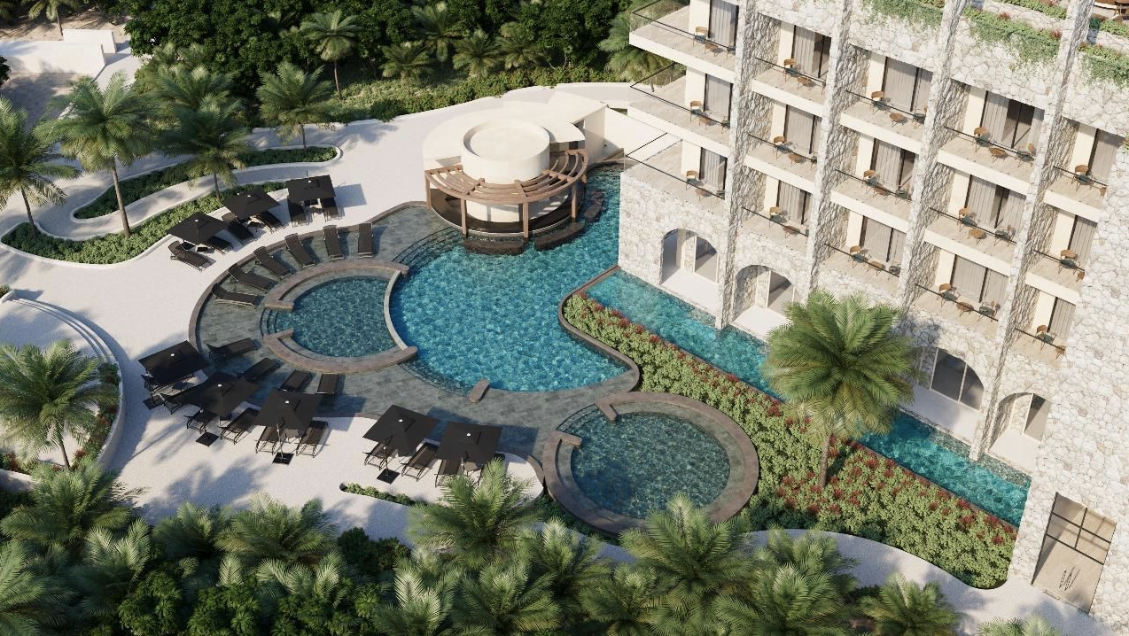 An aerial view of a hotel pool and rooms with balconies 