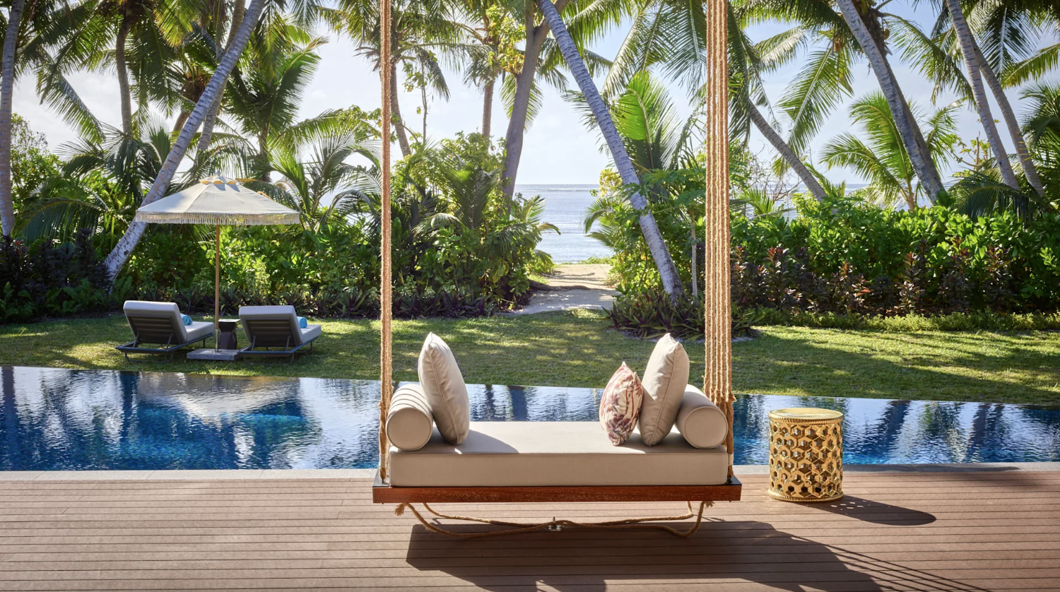 a hotel room patio with a swinging daybed, private pool and beach access. 
