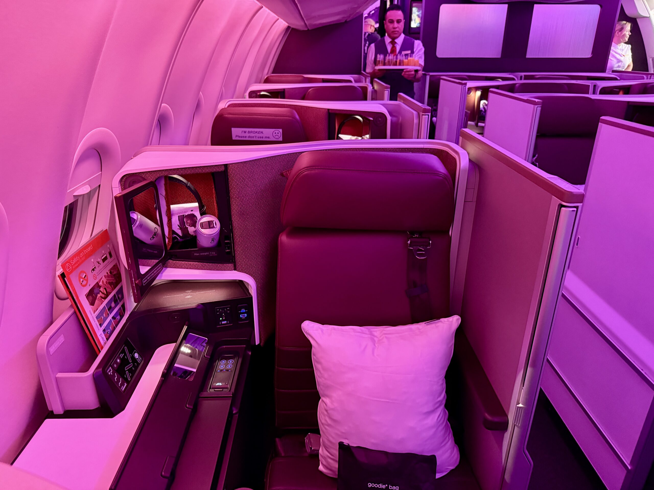 airplane seat with a pillow and black bag 