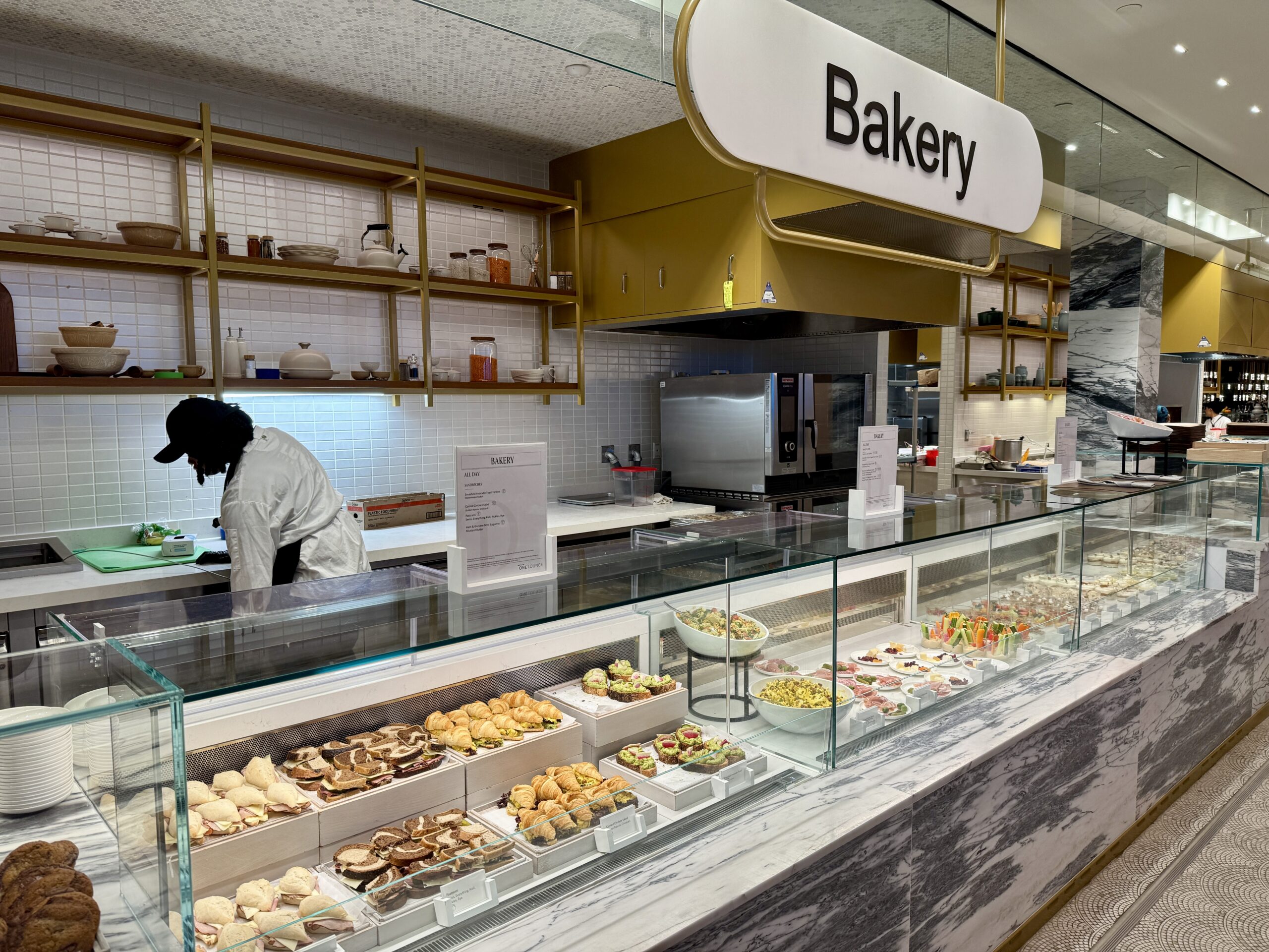an employee working behind a glass encased bakery display