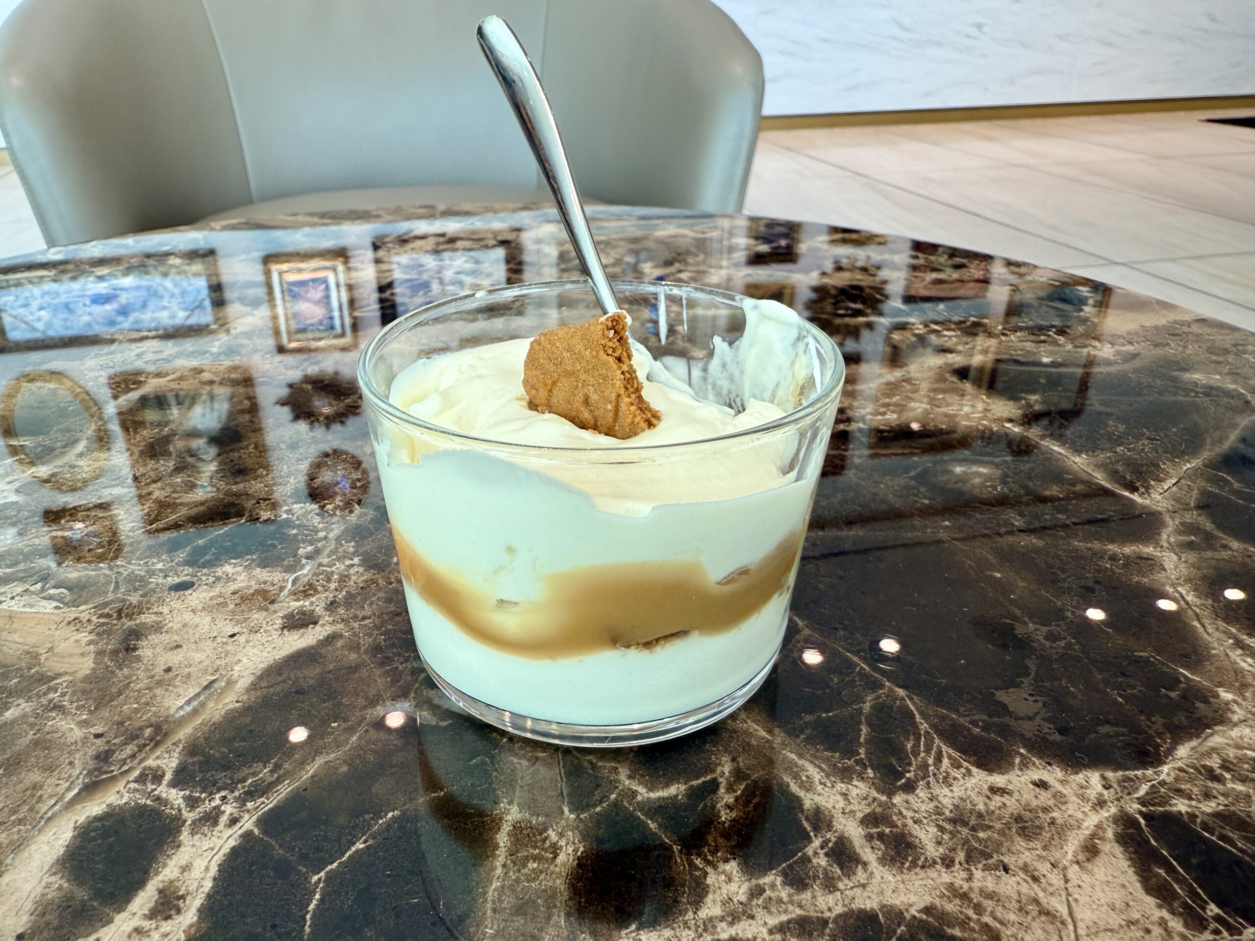 a cup of pudding with a cookie and spoon sticking out of the top