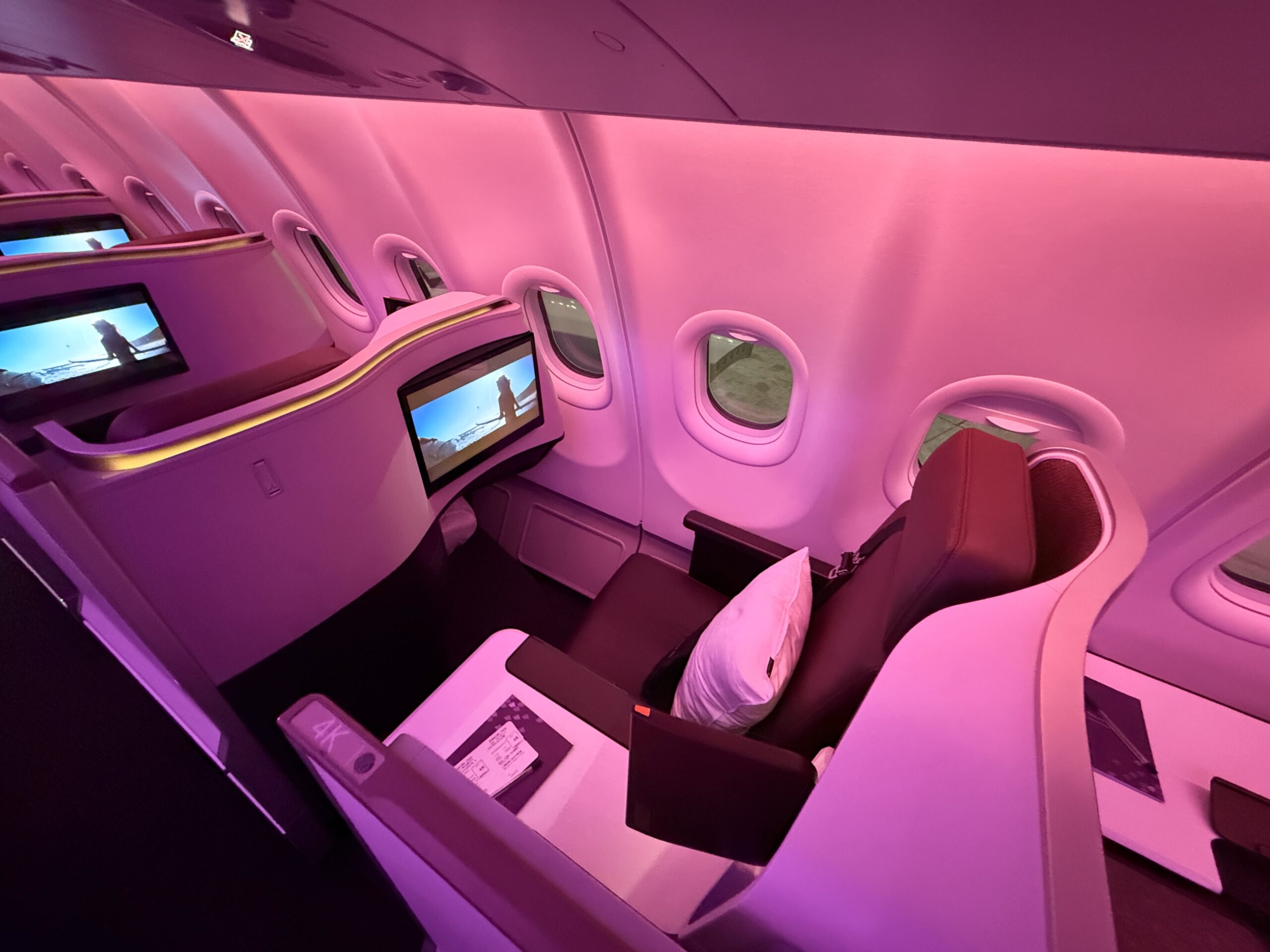 a business class suite with purple and red lighting