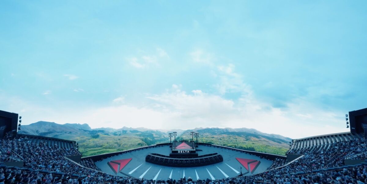 a large stage with a sky behind it and delta logos