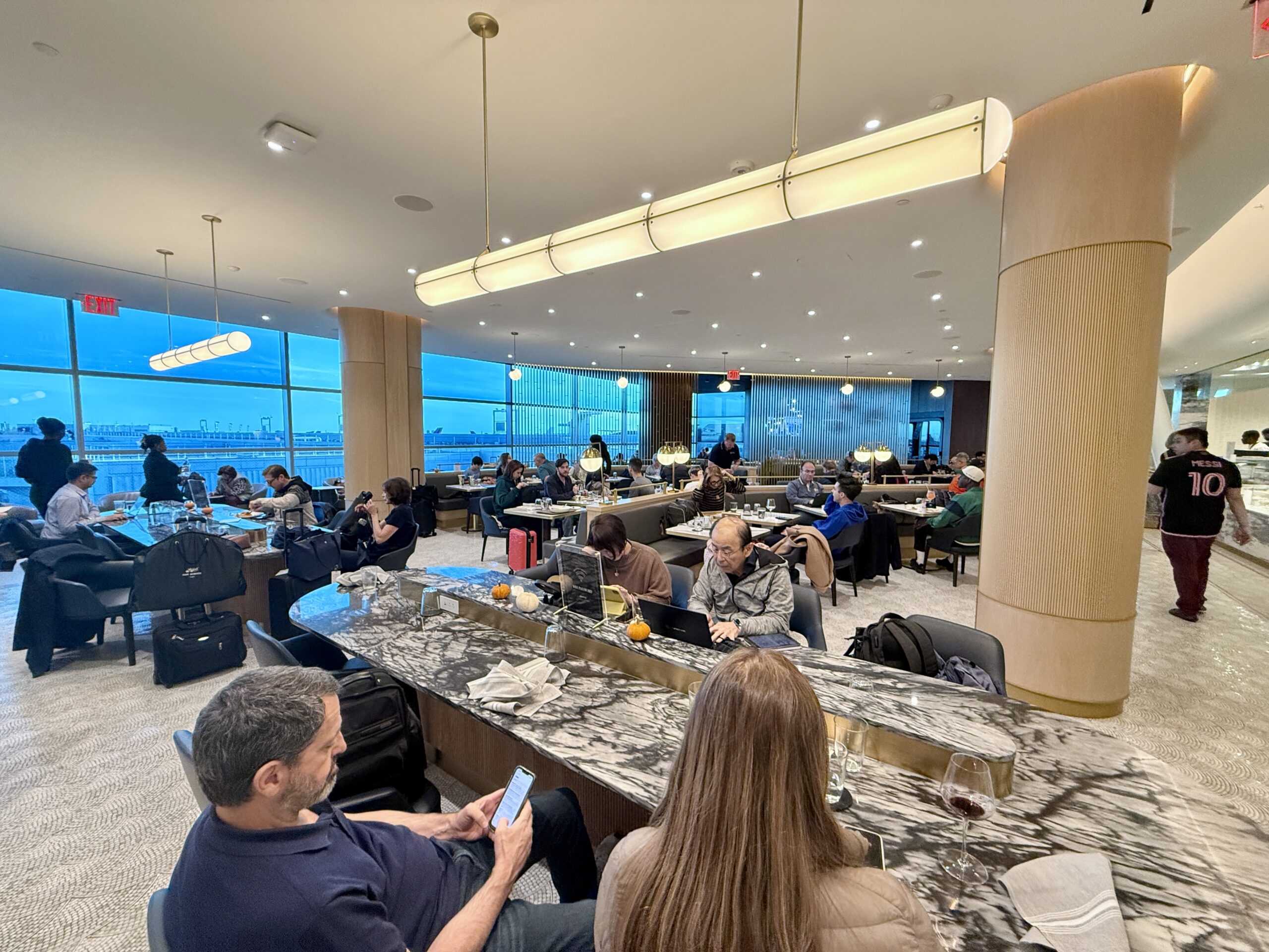 people sitting at tables in airport lounge dining room
