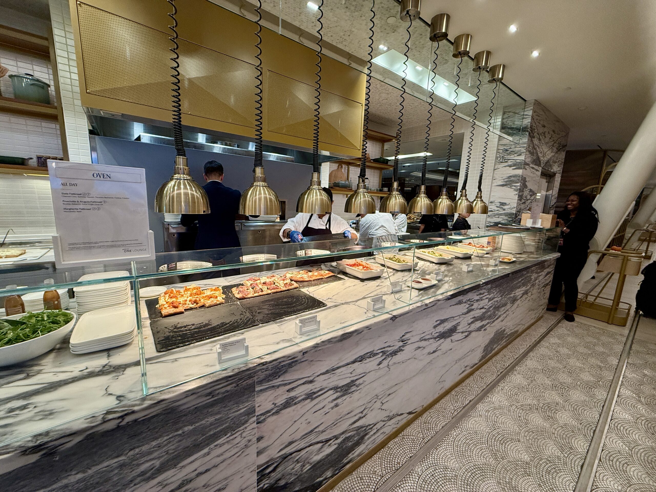 flatbread and dishes of pasta under heating lamps
