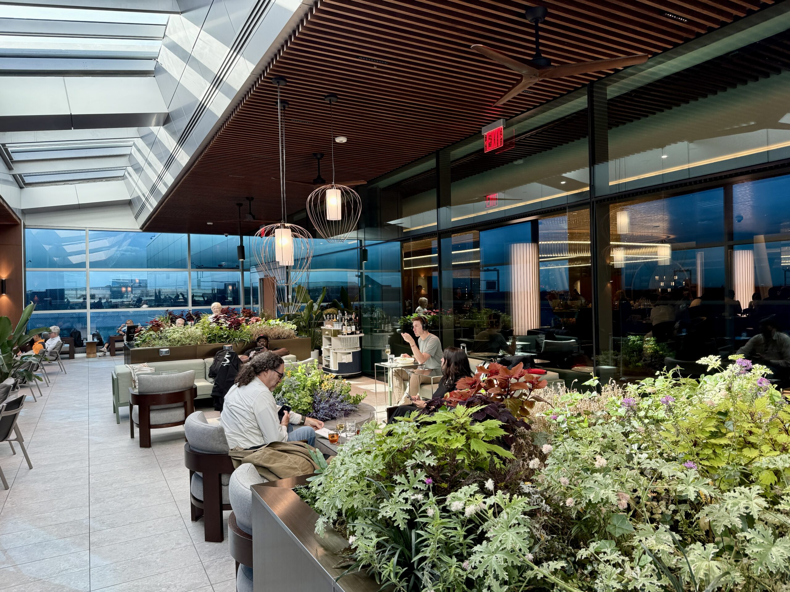 outdoor terrace with plants and people sitting in armchairs