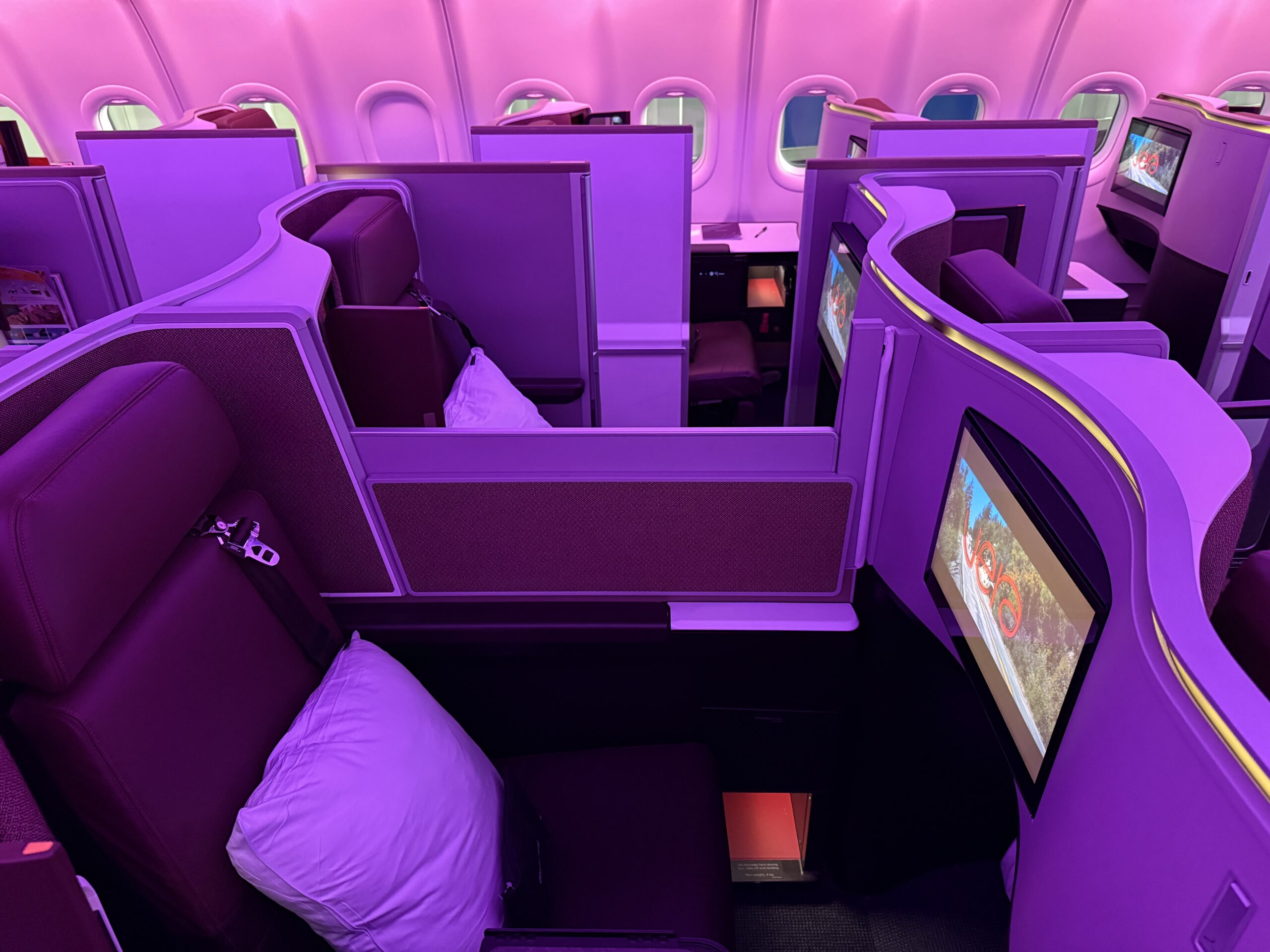 business class seats in the center aisle of a plane with privacy dividers 