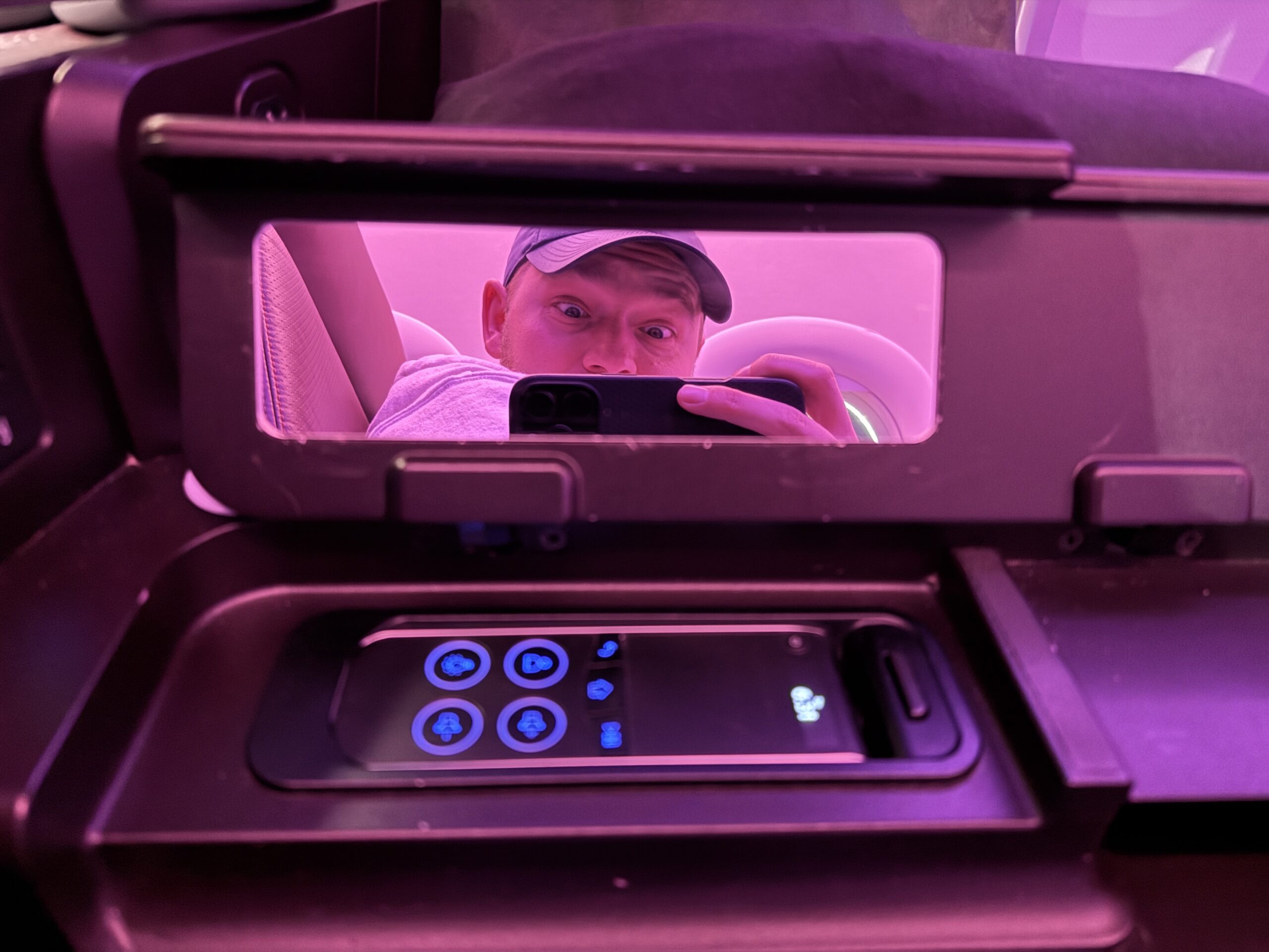 a man in a small mirror with a wired remote control underneath it