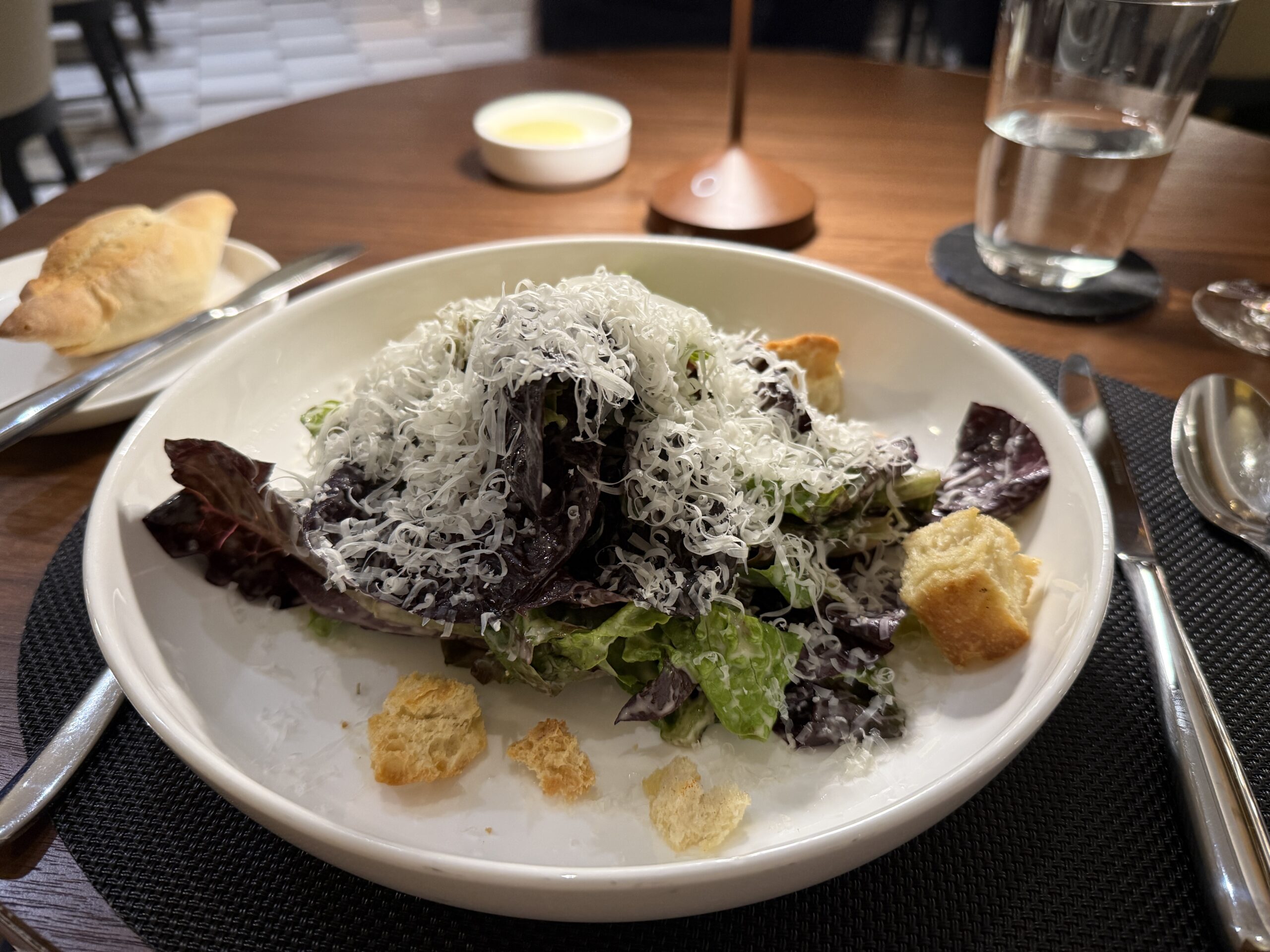 salad on a white plate covered in cheese and croutons