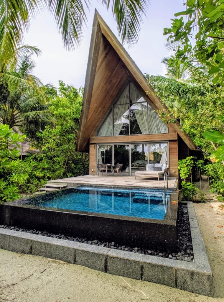 St. Regis Maldives Vommuli beach villa with square pool, table and chairs and daybed with a patio