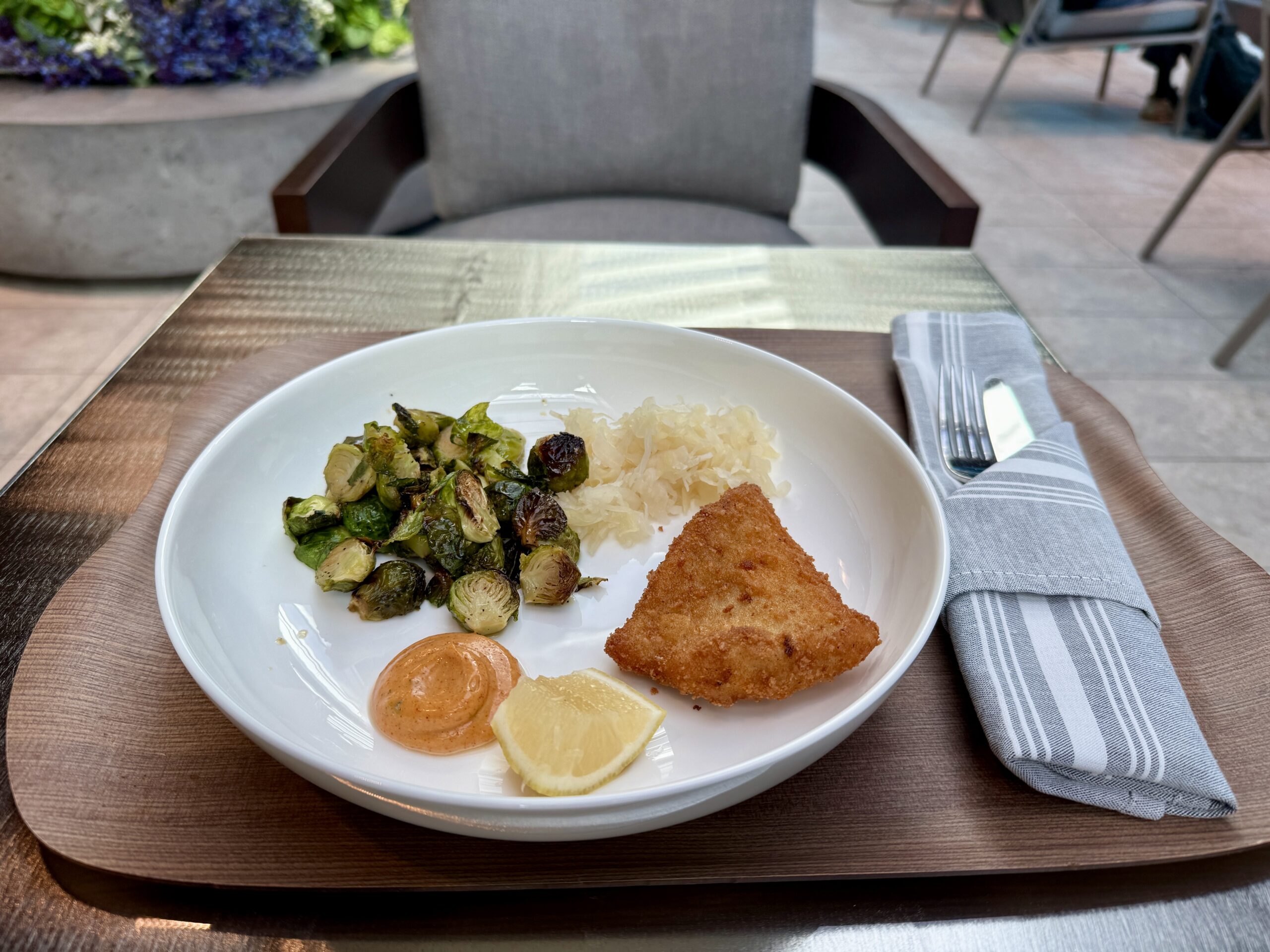 tray of chicken and brussels sprouts with orange sauce and a lemon